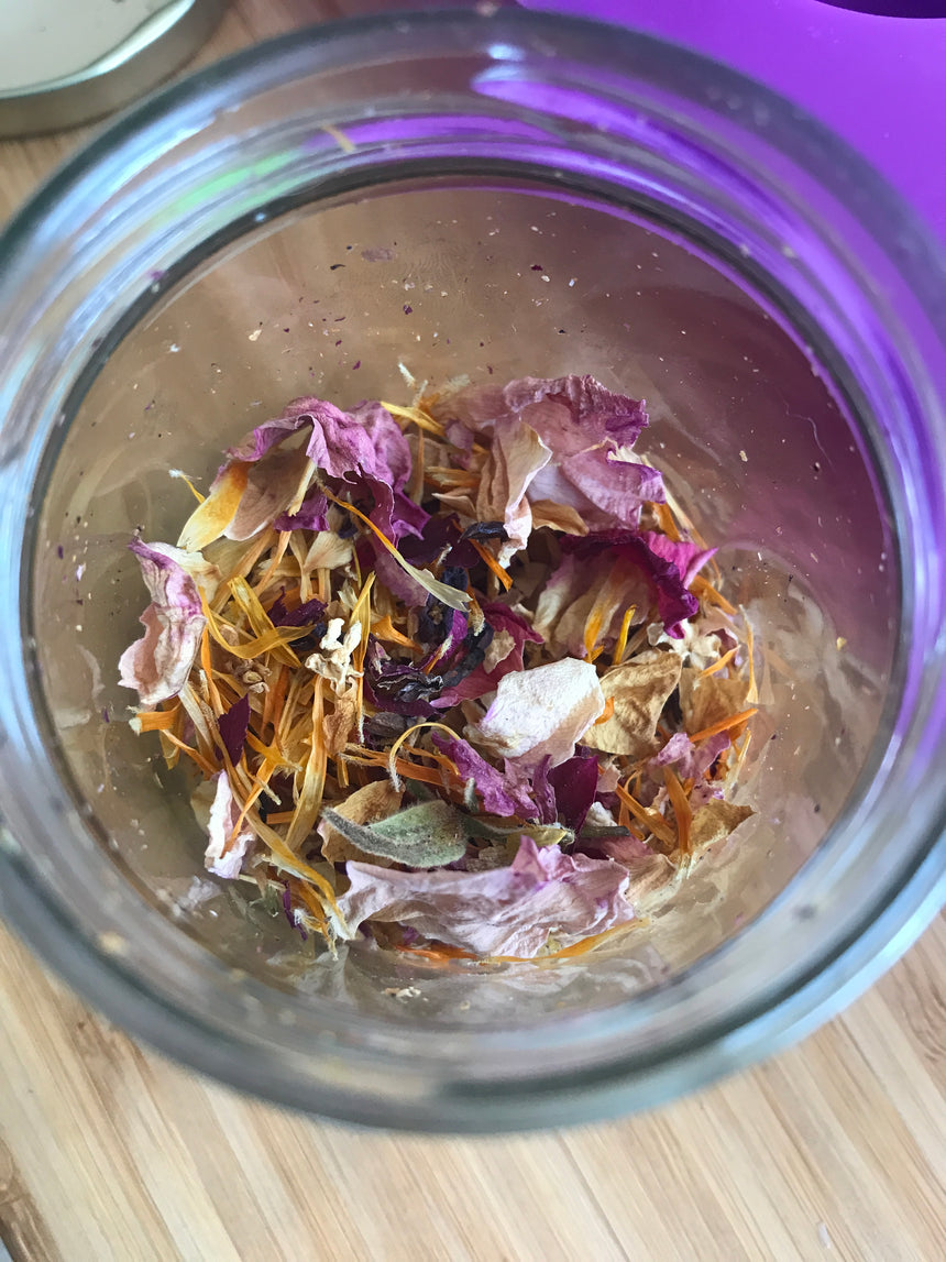 Dried rose and calendula petals in a clear glass jar